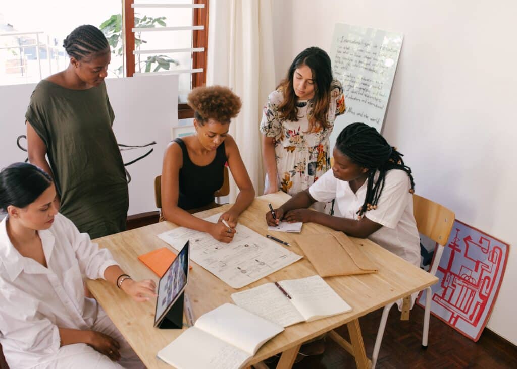 Un grupo de personas se encuentran en una oficina, sentados alrededor de una mesa, analizando datos de una campaña publicitaria