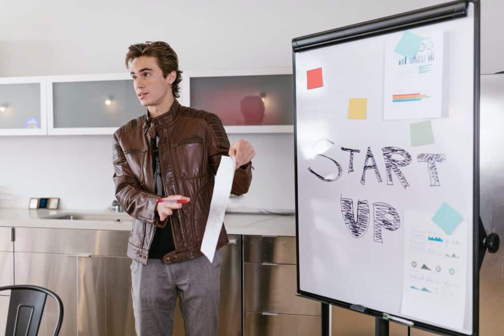 Un chico se encuentra en una oficina, está realizando una presentación de un proyecto de Marketing.